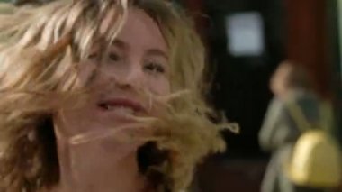 Çok mutlu ve neşeli kız sarışın kıvırcık saçlı başını ve saçlarını hareket sol ve sağ salıncak