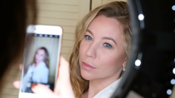 Donna scattare foto di una bella ragazza con smartphone throung una lampada ad anello led — Video Stock