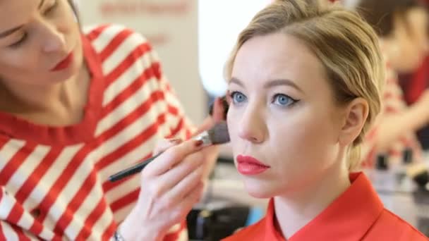 Professionele make-up kunstenaar werken met mooie jonge vrouw — Stockvideo