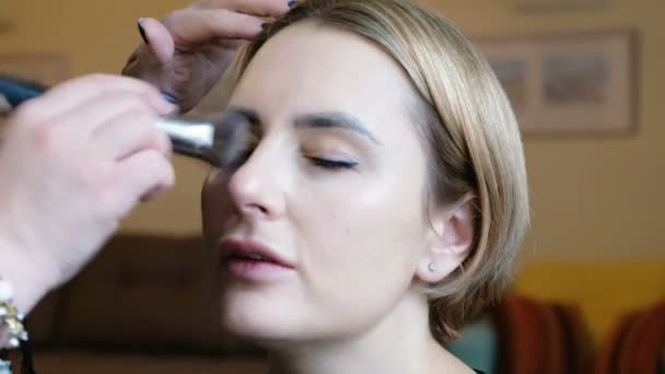 Professionell makeup artist arbetar med vacker ung kvinna — Stockvideo