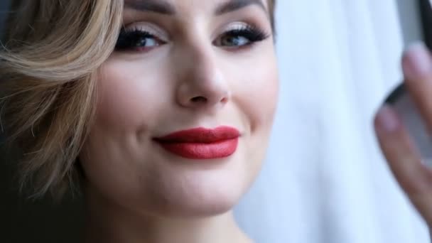 Великолепная женщина с профессиональным макияжем глядя в камеру, отправить поцелуй и улыбаясь — стоковое видео