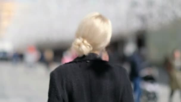 Женщина с профессиональным макияжем смотрит в камеру и улыбается, на улице — стоковое видео
