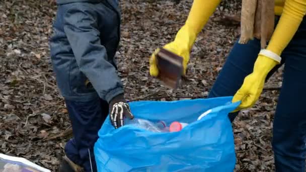 Mulher voluntária com o filho a limpar o lixo junto ao rio. Conceito de ecologia e ambiente — Vídeo de Stock