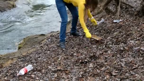 Kadın gönüllüsü nehir kenarında çöpü temizliyor. Açık havada çöp toplamaya. Ekoloji ve çevre konsepti — Stok video