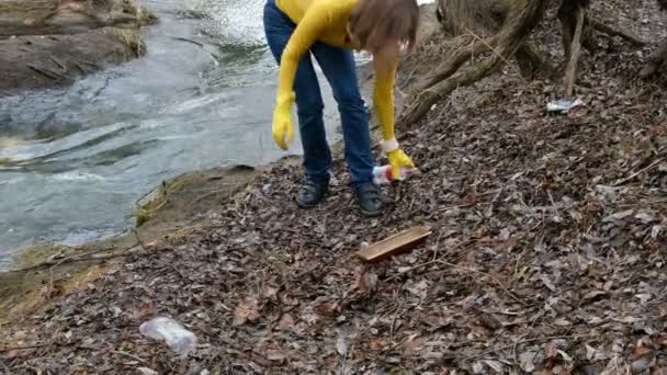 Une volontaire nettoie les poubelles près de la rivière. Ramasser les ordures à l'extérieur. Concept écologie et environnement — Video