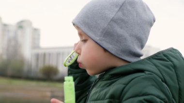 Nehir tarafından kabarcıklar ile küçük sevimli çocuk, açık havada