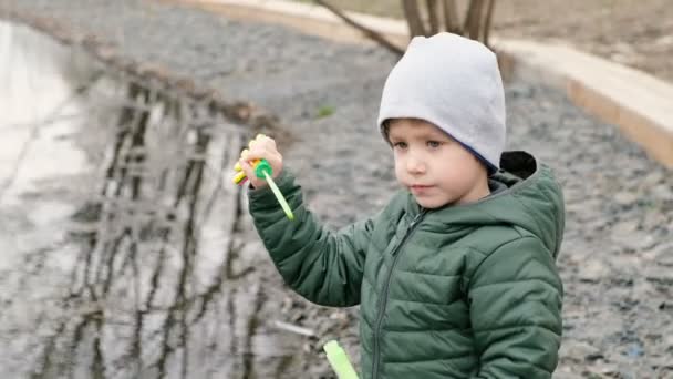 Liten söt pojke med bubblor vid floden, Utomhus — Stockvideo