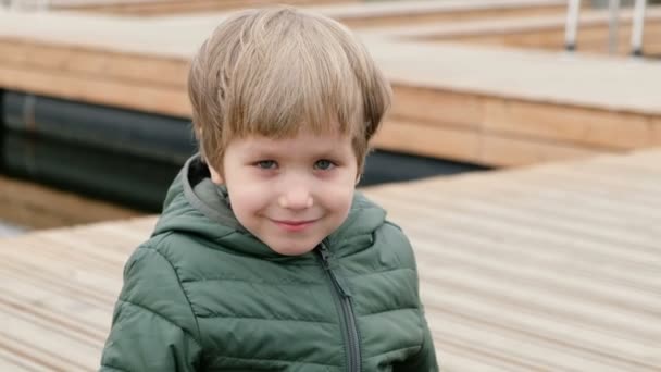 Schattige kleine jongen kijken naar camera en glimlachend — Stockvideo