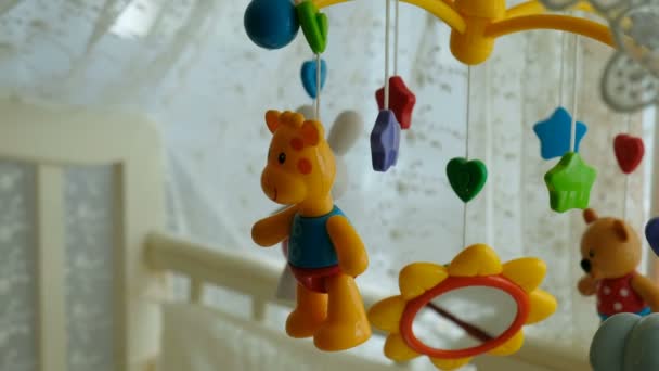 Baby mobile with different toys in the form of animals and stars, above the baby bed — Stock Video