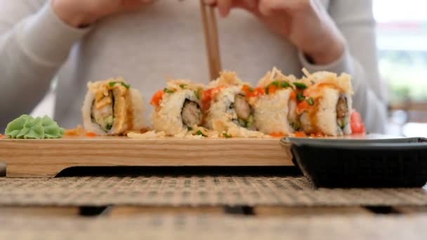 Mujer eatinf sushi rollos en japonés restaurante, de cerca — Vídeo de stock