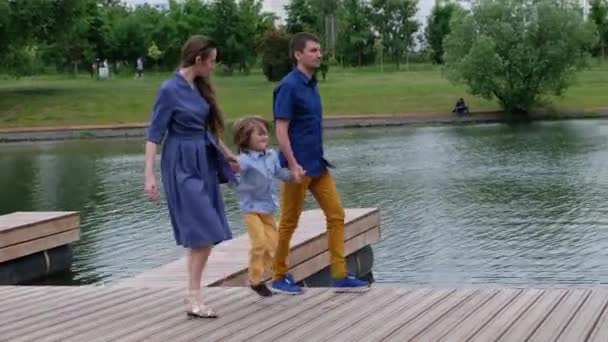 Šťastný rodinný koncept: matka, otec a malý chlapec, kteří chodí po řece a baví se