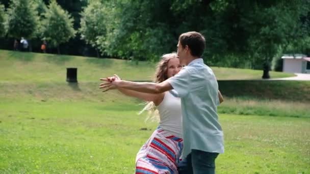 快乐的年轻爱夫妇跳舞华尔兹在公园，夏天户外 — 图库视频影像