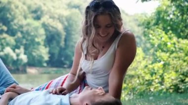 Nehir kıyısında parkta oturan sevgi dolu çift, şefkat ile iletişim, sarılma