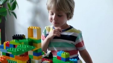 Sevimli çocuk evde masada renkli plastik oyuncak tuğla ile oynarken 4 yaşında.