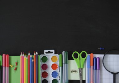 Siyah tahta arka planda okul malzemeleri. Okul konseptine geri dönelim. Yukarıdan görüntüle