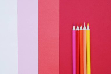 Renkli kalemler ile soyut geometrik kağıt arka plan. Pembe ve mercan moda renkler. Okul ve eğitim kavramı.