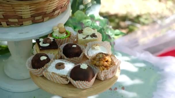 Hermosos pasteles pequeños en el bar de dulces de verano al aire libre para el cumpleaños — Vídeo de stock