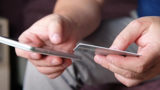 스마트 폰과 온라인 뱅킹. 스마트 폰을 사용하여 쉽게 지불 할 수 있습니다. 남자는 신용 카드로 온라인 쇼핑. 손을 닫습니다. — 비디오