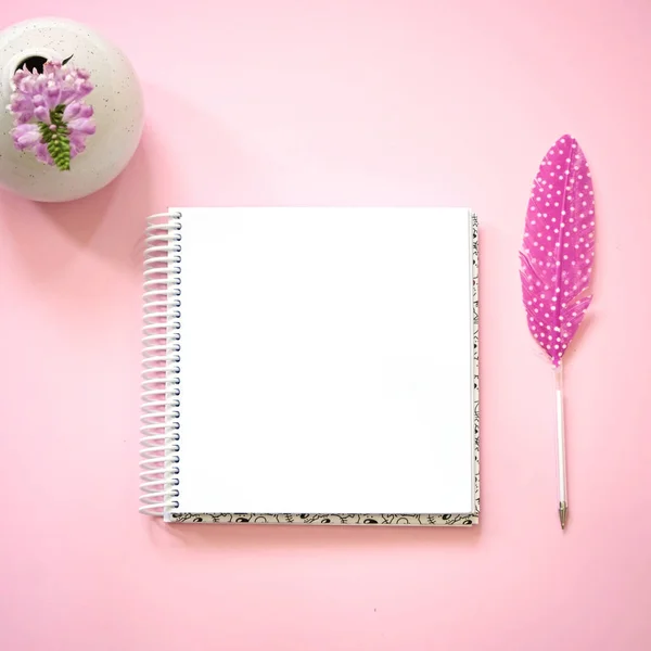 Bloc de notas en blanco, flores y pluma como maqueta para su diseño. Fondo rosa, estilo laico plano . — Foto de Stock