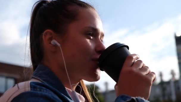 Jong mooi meisje drinken koffie buitenshuis — Stockvideo