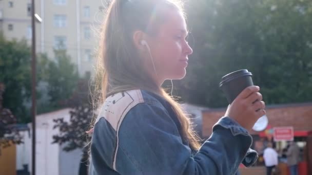 Молода красива дівчина п'є каву на відкритому повітрі — стокове відео