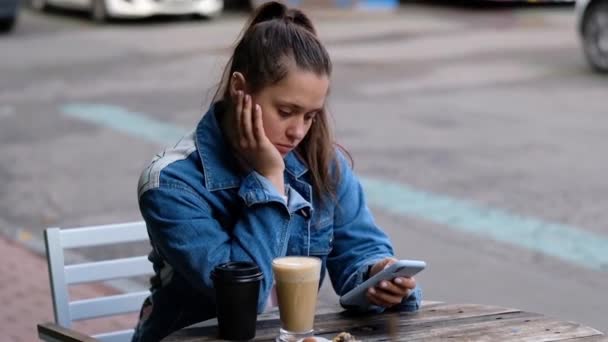 Jovem menina bonita beber café ao ar livre — Vídeo de Stock