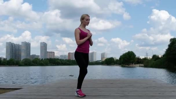 Jovem mulher esportiva fazendo esportes ao ar livre, exercícios de fitness. Conceito de fitness e estilo de vida — Vídeo de Stock