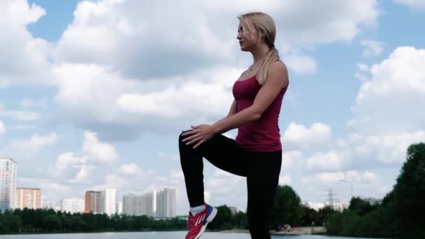 Fiatal sportos nő sportolás közben a szabadban, fitness gyakorlatokat. A fitnesz és életmód fogalma — Stock videók