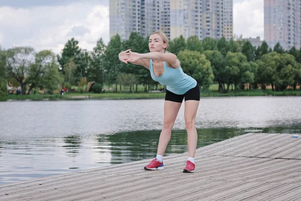 Fiatal sportos nő sportolás közben a szabadban, fitness gyakorlatokat. A fitnesz és életmód fogalma — Stock Fotó