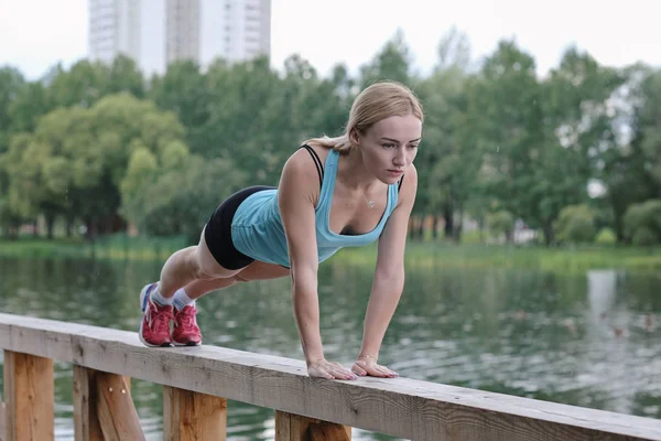 Fiatal sportos nő sportolás közben a szabadban, fitness gyakorlatokat. A fitnesz és életmód fogalma — Stock Fotó