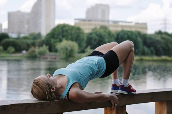 Giovane donna sportiva che fa sport all'aperto, esercizi di fitness. Fitness e stile di vita concetto — Foto Stock