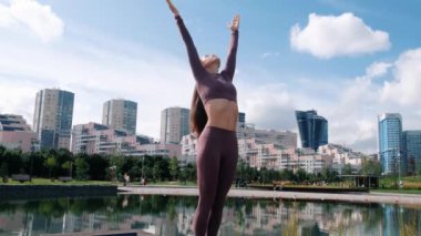 Şehirde surya namaskar pratik genç kadın. Spor ve yoga konsepti.
