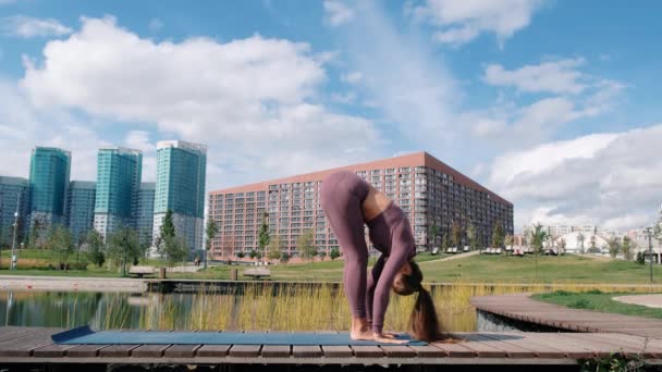 Jonge vrouw doet yoga oefeningen met stad op achtergrond. Ademhaling. Relax en Freedom concept. — Stockvideo