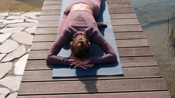 Jeune femme faisant des exercices de yoga avec la ville sur fond. eka pada rajakapotasana, pose de pigeon — Video