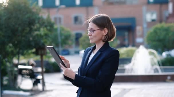 Jovem mulher de negócios usando tablet pc, ao ar livre — Vídeo de Stock