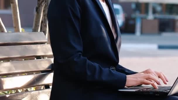 Молодая деловая женщина работает с ноутбуком на открытом воздухе — стоковое видео