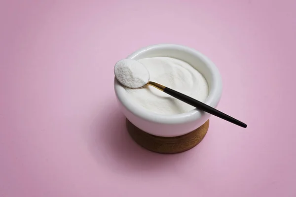 Collagen protein powder in a bowl with a modern spoon on pink background — Stock Photo, Image