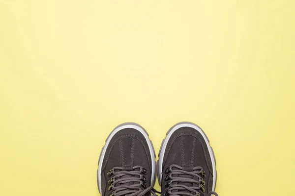 Moderní sportovní boty, tenisky na žlutém pozadí. Pohled shora. — Stock fotografie