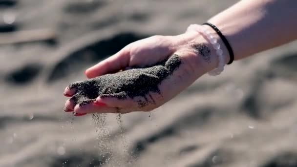 Womans hand with black volcanic sand on the beach of mediterranean sea in Rome — Stock Video
