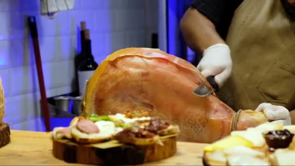 Senior chef die jamon prosciutto ham uitspreekt in een restaurant, Italiaanse of Spaanse keuken — Stockvideo