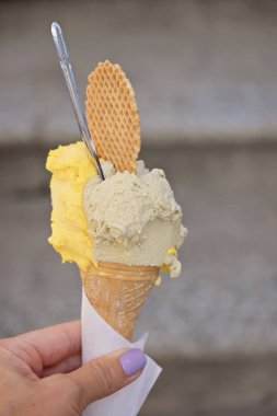 İtalyan dondurması külahta - mango ve şam fıstığı - kadınların elinde dondurma