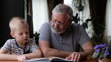 Büyükbaba kıdemli adam torunuyla kitap okuyor.