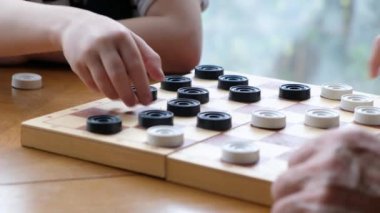 Küçük çocuklar dedenle dama oynuyorlar. Yaklaş.