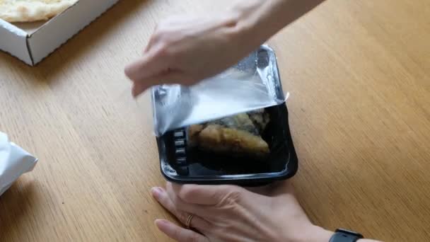 Vrouwen hand openen plastic doos met sushi, Japanse food delivery service. Sluiten. — Stockvideo