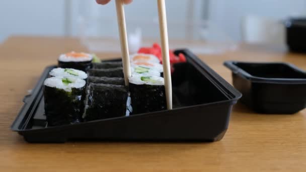 Mujeres mano tomando rollos de sushi de caja de plástico, servicio de entrega de comida japonesa — Vídeo de stock