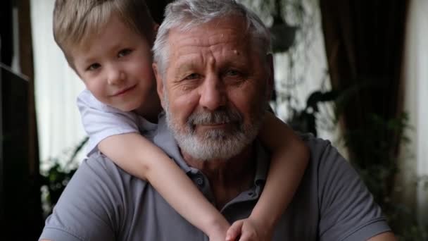 Senoir anciano feliz hombre abuelo con nieto niño mirando a la cámara, sonriendo y abrazando — Vídeo de stock