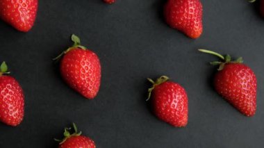 Sulu çilek yarımları ile siyah dönen arkaplan, kapat