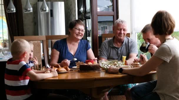 Una gran reunión familiar en la mesa. Personas Divirtiéndose, Comunicándose y Comiendo en Interiores . — Vídeos de Stock