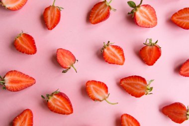 Pembe arka plan, taze çilek parçaları, üst manzara.