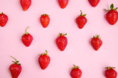 Pembe arka plan, taze çilek parçaları, üst manzara.